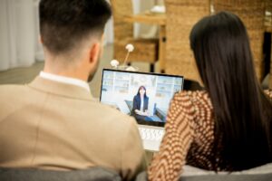 Young couple listening to family psychologist during online session