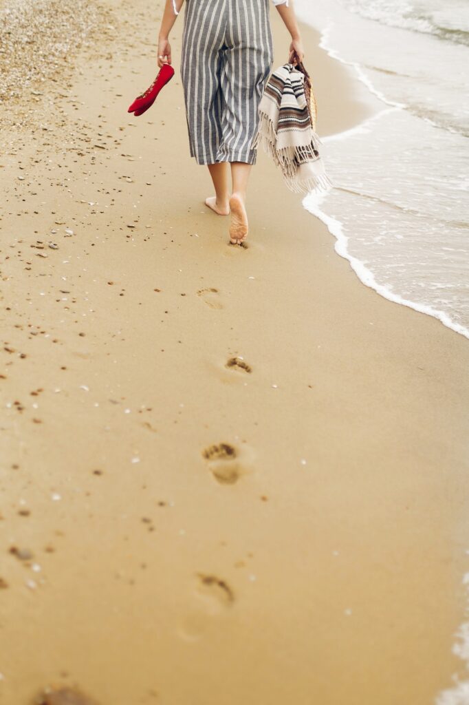 Woman walking barefoot on beach